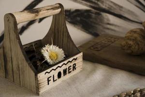 getrocknete Blume in einer Holzkiste auf dem Tisch. skandinavischer Stil foto
