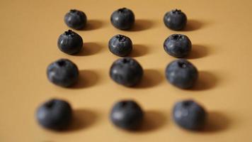 Heidelbeeren sind in Reihen auf goldenem Hintergrund angeordnet foto