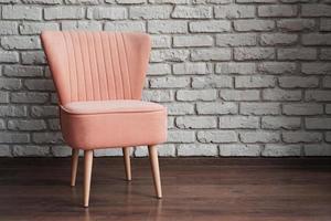 rosa Stuhl auf einem weißen Backsteinmauerhintergrund foto
