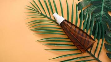 Sonnencreme-Flasche auf Hintergrund mit tropischem Blatt foto