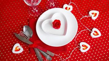 ein weißer Teller mit Messer und Gabel auf leuchtend rotem Grund foto