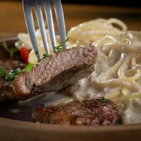 Spaghetti mit Rindfleisch und Sahne Soße auf ein Platte, selektiv Fokus foto
