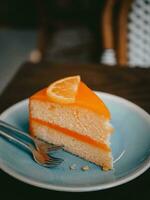 Orange Kuchen mit Orange Scheibe auf Blau Teller im Cafe, Lager Foto