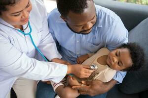 Pädiatrie Arzt mit Stethoskop zum Lunge oder Truhe Untersuchung zum Prüfung süß wenig Mädchen im medizinisch Gesundheitswesen Krankenhaus oder Klinik. Arzt prüfen Herz und Lunge zum lächelnd afrikanisch amerikanisch Baby. foto