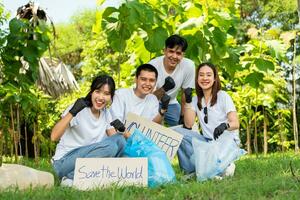 glücklich jung asiatisch Studenten vielfältig Freiwillige halt ein Kampagne Zeichen zum Reinigung im das Park, das Konzept von Umwelt Erhaltung auf Welt Umgebung Tag, Recycling, Nächstenliebe zum Nachhaltigkeit. foto