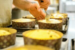 Koch produzieren Panettone, während lievitieren, Hinzufügen Mandel Zucker Belag zu roh Süss Brot. foto