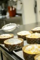 Koch produzieren Panettone, während lievitieren, Hinzufügen Mandel Zucker Belag zu roh Süss Brot. foto