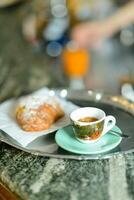 ein Tablett mit Espresso Kaffee, Orange Saft und Croissant Brioche auf Bar Zähler im das Morgen foto