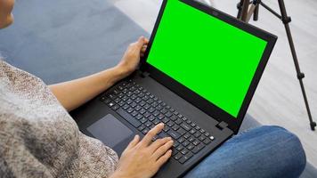 Frau mit Laptop mit grünem Bildschirm. Frau tippt