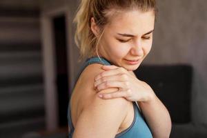 Frauen, die Sportanzüge tragen, haben nach dem Training Schulterschmerzen foto