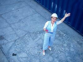 weiblich Frau Weiß Helm Helm Haut aussehen beim Kamera Person Menschen Mensch Bericht Papier Tablette prüfen oben importieren Export Industrie Container Architekt Sicherheit Vorarbeiter Lächeln glücklich Container Konstruktion foto