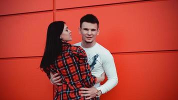 Paare, die sich an einem sonnigen Tag verlieben und umarmen - roter Hintergrund foto
