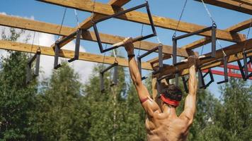 Mann, der während des Hindernislaufs im Bootcamp Hürden überwindet foto