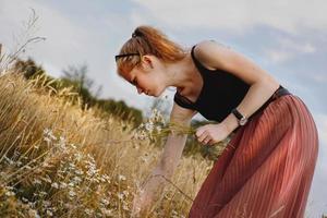 junge Frau, die Natur und Sonnenlicht im Strohfeld genießt foto