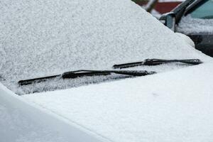 Schnee bedeckt Auto Windschutzscheibe, Scheibenwischer und Motorhaube foto