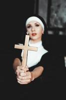 Nonne, die ein Kreuz hält. der Religionsbegriff. foto