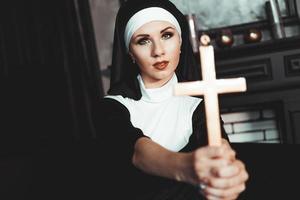 Nonne, die ein Kreuz hält. der Religionsbegriff. foto