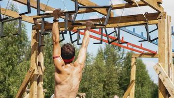 Mann, der während des Hindernislaufs im Bootcamp Hürden überwindet foto