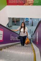 junge Frau steht auf Rolltreppe im Einkaufszentrum einkaufen foto