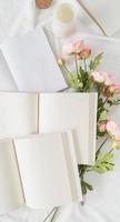 Geöffnete Bücher und Blumen Draufsicht auf weißes Bett. Mock-up-Design foto