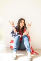 schöne junge Frau mit amerikanischer Flagge auf weißem Hintergrund foto