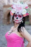 Porträt von ein Mädchen mit Zucker Schädel bilden Über schwarz Hintergrund. Calavera catrina. dia de los Muertos. Tag von das tot. Halloween. foto