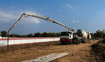 Gießen Beton mit ein Rührgerät LKW dann mit ein Beton Pumpe zu drücken das verarbeitet Beton Flüssigkeit von das Rührgerät LKW foto