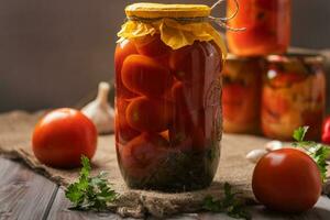 hausgemacht Gläser von eingelegt Tomaten auf ein rustikal hölzern Hintergrund. eingelegt und Dosen- Produkt. Nächster Tomaten und andere zum Kochen. foto