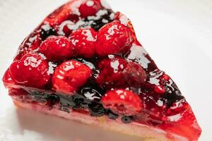 Stück von Kuchen mit Beeren, Himbeere, Erdbeere, Johannisbeere, auf ein Weiß Hintergrund, Nahansicht foto