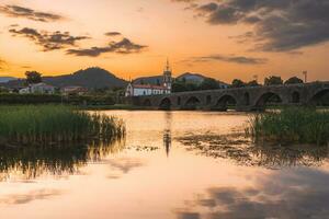 Sonnenuntergang beim das mittelalterlich Brücke beim ponte de Lima, Portugal. foto