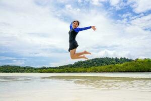glücklich asiatisch Teen Mädchen Springen Spaß auf das Strand foto