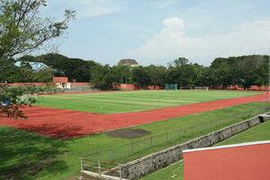 Sport Feld mit Grün Gras und Gebäude foto