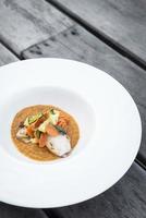 Gourmet gefüllter Tintenfisch mit Gemüse in würzigem Kürbis-Curry-Püree foto