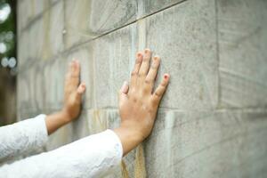 Hände schieben gegen das Stein Mauer mit großartig Macht foto