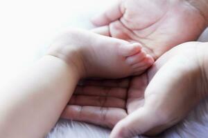 Baby Füße im Hand, Mutter, winzig Neugeborene Baby Füße auf Hand, weiblich Foto, Nahaufnahme, Mutter und ihr Kind, glücklich Familie Konzept, schön Konzept Bild von Geburt. foto