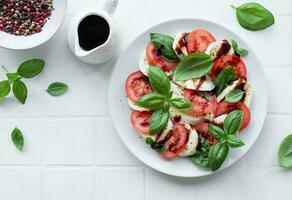 Caprese-Salat mit Tomaten, Mozzarella und Basilikum. foto