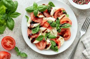 Caprese-Salat mit Tomaten, Mozzarella und Basilikum. foto