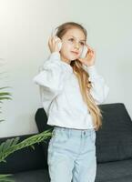 süß wenig Mädchen Hören zu Musik- im Kopfhörer foto