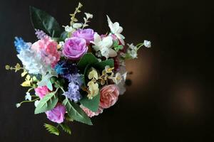 schön Plastik Blühen Rose Blumen und Flora Strauß auf schwarz Glas oben von Tabelle dekoriert im Garten foto