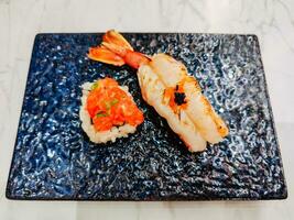 gegrillt Garnele Sushi und Lachs Rogen Sushi im ein Platte. zusammen, das zwei Sushi Kontrast im Textur und Geschmack das zärtlich Wärme von Garnele nebeneinander mit das Cool, knallen Sensation von Rogen. foto