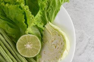 Grünkohl, Limette, Bohnensalat auf einem weißen Teller foto