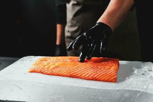 Nahansicht von Koch Hand bereit zu Kochen frisch Lachs füllen foto