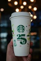 Bangkok, Thailand - - Oktober 23, 2023 Mann halten wiederverwendbar Tasse, 25 Jubiläum, Starbucks Thailand, erhalten 1 frei. limitierte Auflage, beschränkte Auflage foto