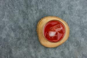 ein Glas von frisch Wassermelone Saft war platziert auf ein hölzern Untersetzer. foto