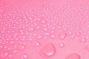 Nahaufnahme von Wassertropfen auf rosa Hintergrund foto