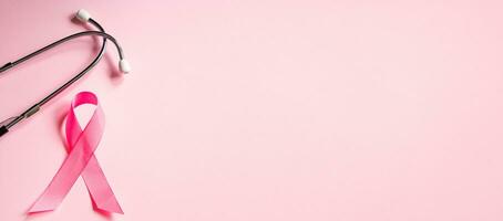 Rosa Schleife und Stethoskop auf farbigem Hintergrund. Brustkrebs-Aufklärungsmonat. Frauengesundheitskonzept. Symbol des Kampfes gegen die Onkologie. foto