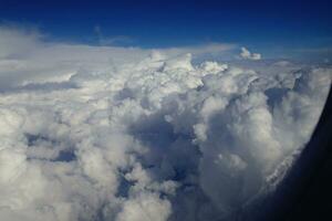 Weiß Wolken gegen das Blau Himmel gesehen von das Flug von das Fenster von das Flugzeug foto