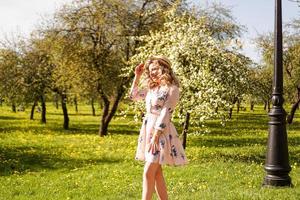 schöne junge Frau im Apfelgarten im sonnigen Frühlingstag foto