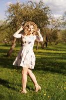 lächelnde Sommerfrau mit Strohhut im Park foto