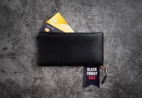 Schwarze Brieftasche mit Text Black Friday Sale auf einem Etikett und Kreditkarten